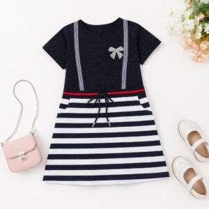 Vestido infantil azul marino de rayas presentado en composición flat lay con accesorios.